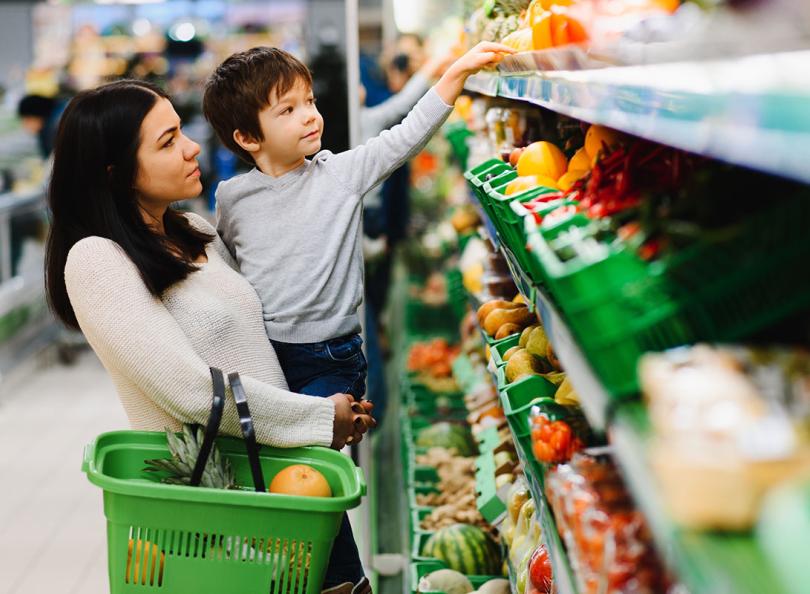 une mère et son enfant font leur courses au supermarché rayon des fruits et légumes 