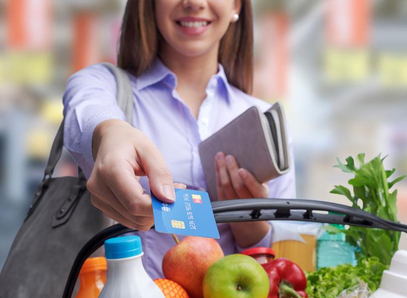 Une femme paye ses courses avec une carte de crédit