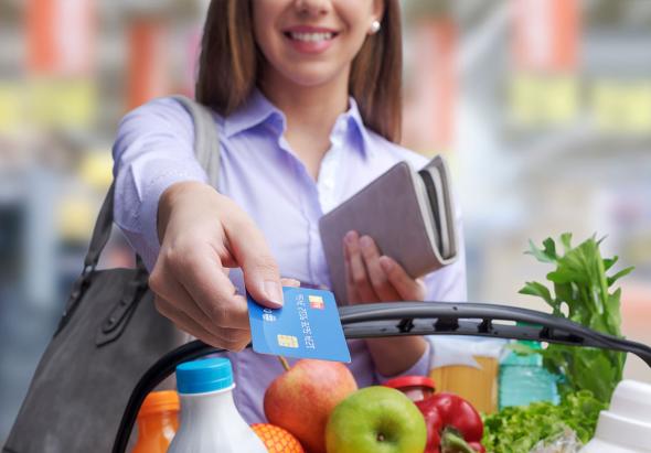 Une femme paye ses courses avec une carte de crédit