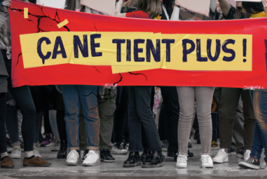 des personnes manifestent dans la rue en tenant une banderole où il est écrit "ça ne tient plus"
