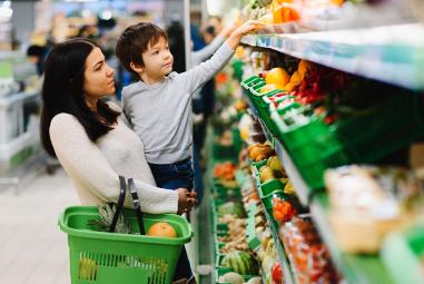 une mère et son enfant font leur courses au supermarché rayon des fruits et légumes 